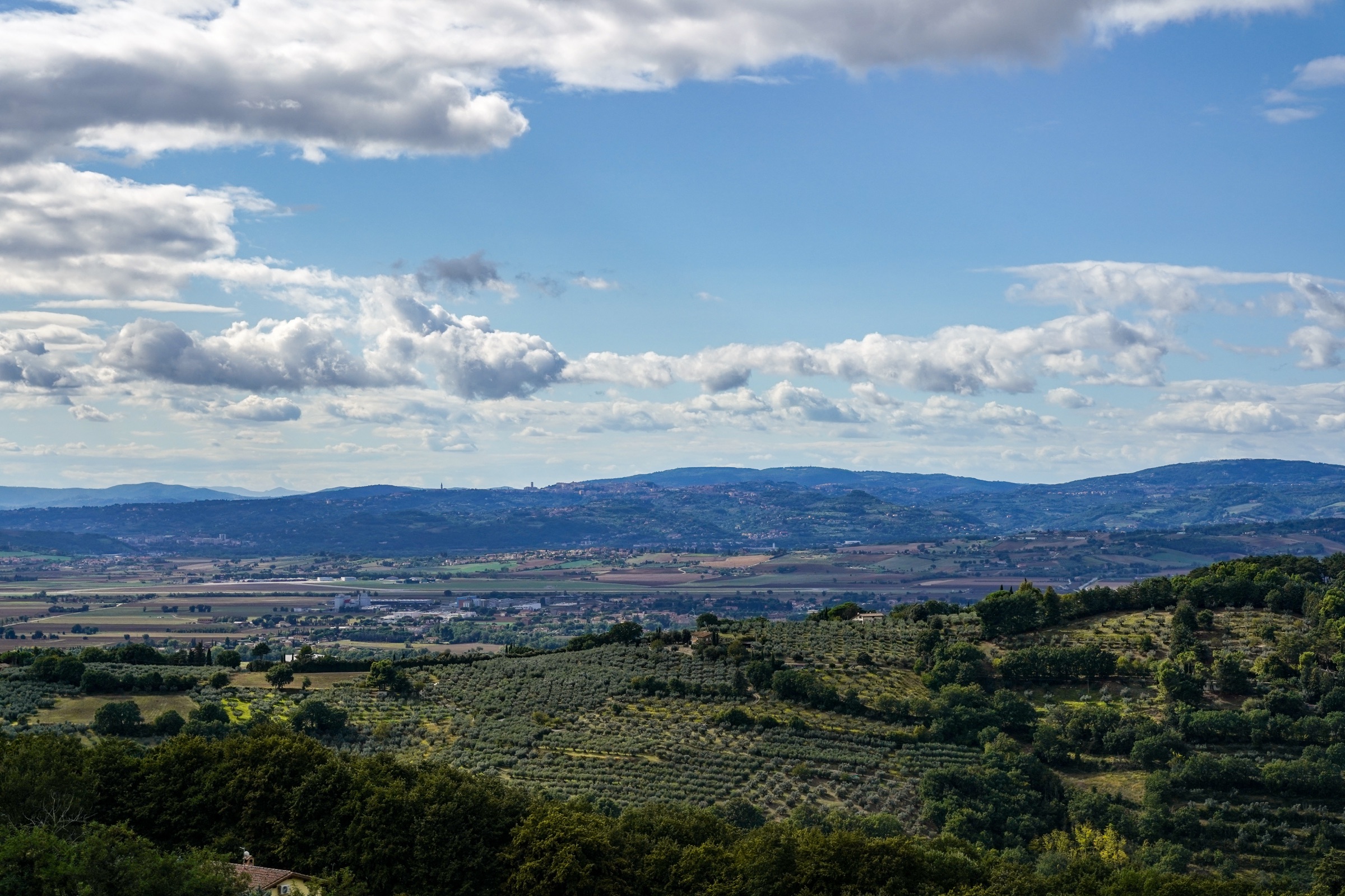 Facciata in pietra di una villa umbra immersa nel paesaggio collinare